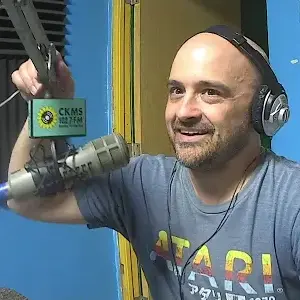A man wearing headphones adjusting a microphone