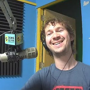 A laughing man at a microphone