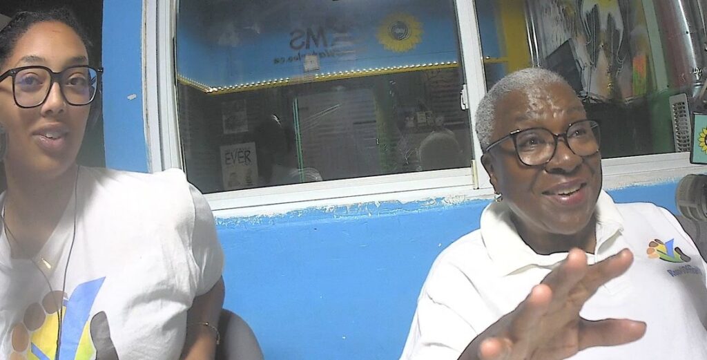 Two women wearing white polo shirts.