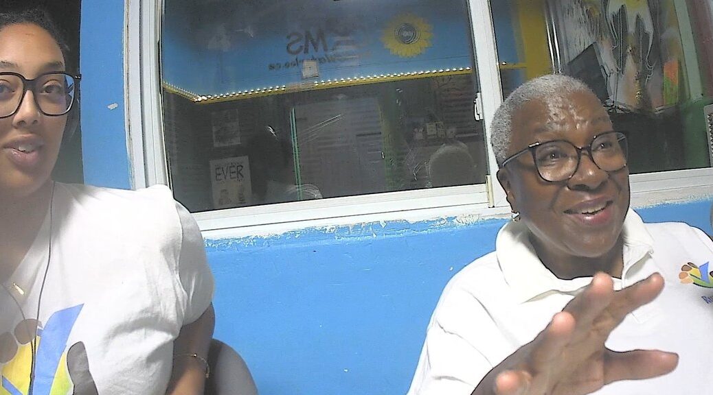 Two women wearing white polo shirts.
