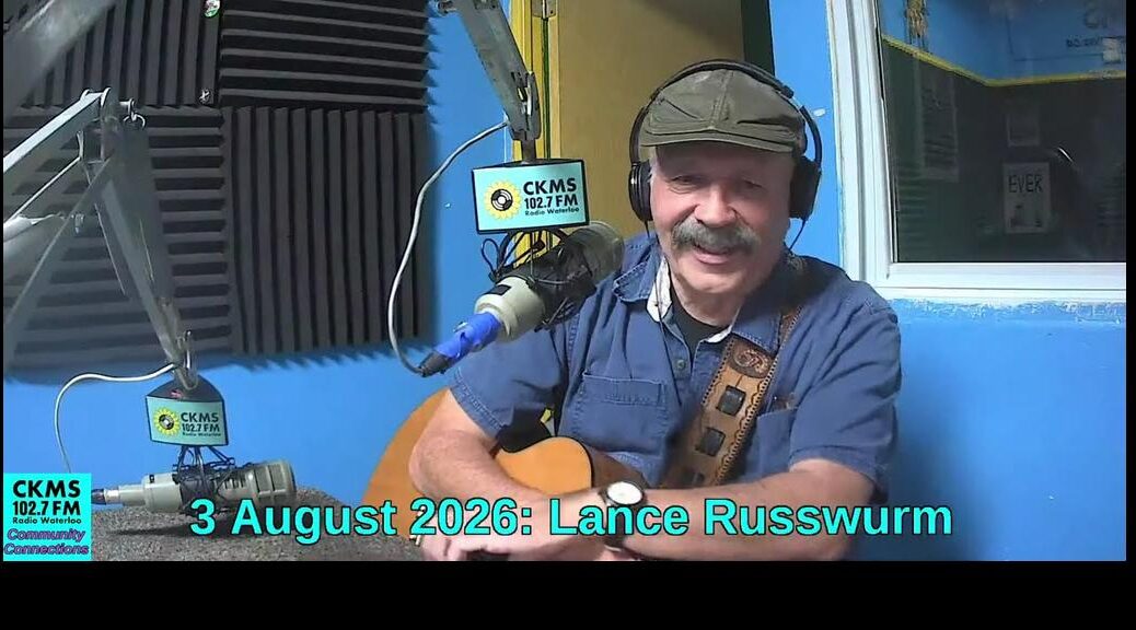 A smiling man with a moustache holding a guitar and wearing a flat cap and headphones sits at a microphone. The CKMS Community Connections icon is at the bottom to the left of "3 August 2026: Lance Russwurm"