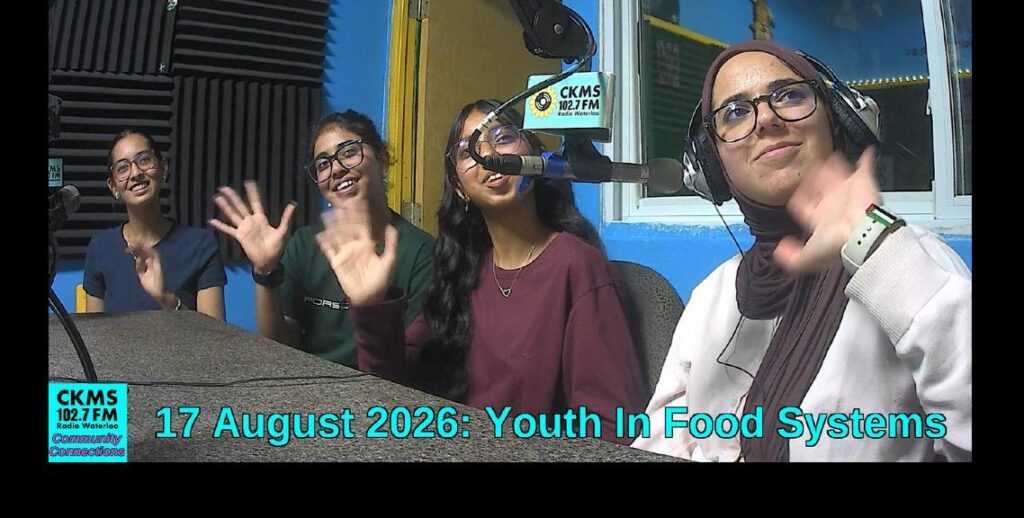 Four women at a table with a microphone, all waving towards the camera. At the bottom is text "17 August 2026: Youth In Food Systems"
