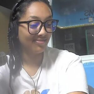A woman wearing headphones smiles to the right.