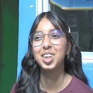 A woman with long dark hair laughing towards the camera.