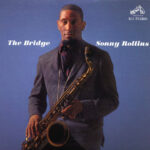 The Bridge | Sonny Rollins (a young many in a checkered jacket looks into the camera while holding an alto saxophone)